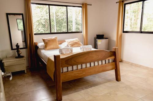 a bedroom with a wooden bed with two pillows on it at Hotel San Sebastian del Tonusco in Santa Fe de Antioquia