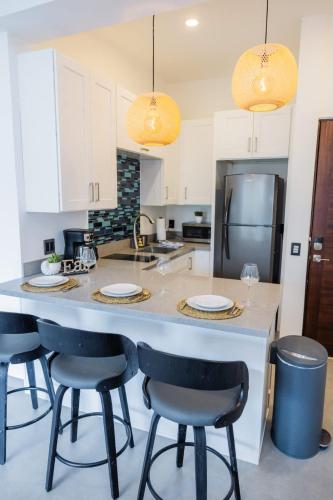 a kitchen with a large island with bar stools at Vista Pedregal-Stylish Holiday Apartment in the Heart of Cabo, 2 Minutes walk to Marina in Cabo San Lucas