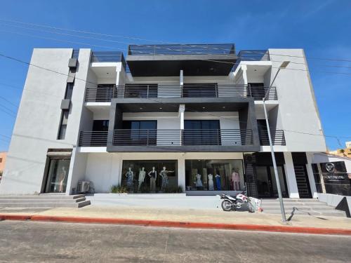 a white building with a motorcycle parked in front of it at Vista Pedregal-Stylish Holiday Apartment in the Heart of Cabo, 2 Minutes walk to Marina in Cabo San Lucas