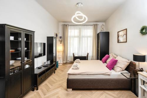 a bedroom with a large bed and a television at Royal Charlie Suite in Prague