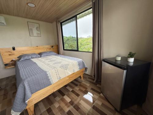 a bedroom with a bed and a window at Cabaña con jacuzzi privado Lago de Sol in El Castillo de La Fortuna