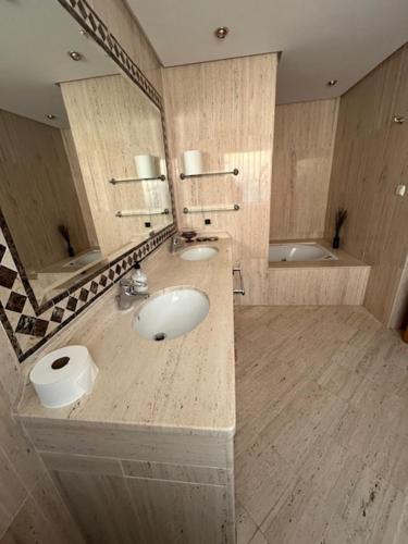 ein großes Bad mit 2 Waschbecken und einem Spiegel in der Unterkunft Chalet pareado in Marbella