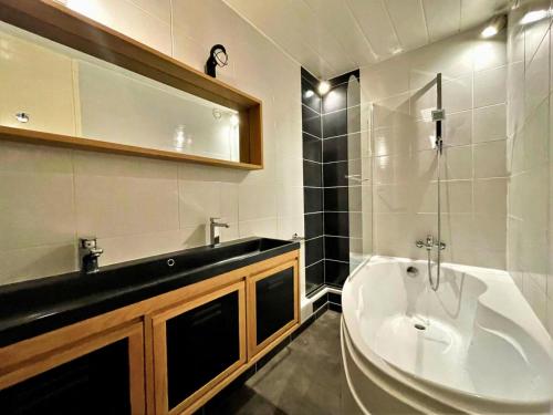 une salle de bain avec un lavabo et une baignoire dans l'établissement Résidence Oisans - Grand appartement pour 8 personnes aux pieds des pistes MAE-4011, aux Menuires