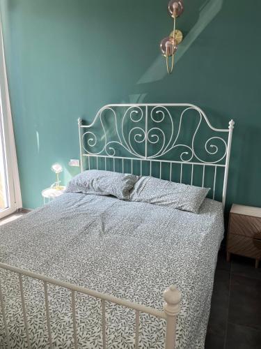 a bedroom with a white bed with a blue wall at Alloggi CH40 in Imperia
