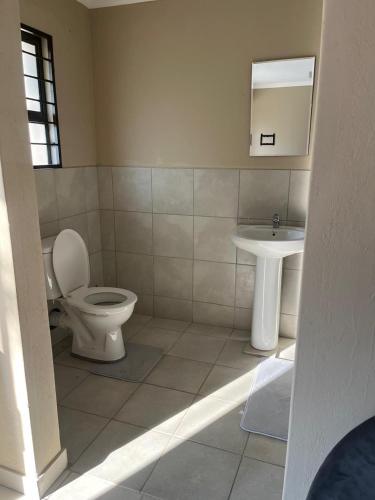 a bathroom with a toilet and a sink at Lesari Stay in Centurion