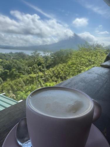 a cup of coffee sitting on a table with a view at Cabaña con jacuzzi privado Lago de Sol in El Castillo de La Fortuna