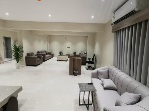 a large living room with couches and a tv at قربان المدينة للشقق الفندقية in Al Madinah