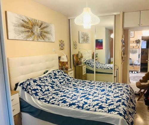 a bedroom with a bed with a blue and white comforter at Appartement spacieux, vue imprenable in Roquebrune-Cap-Martin
