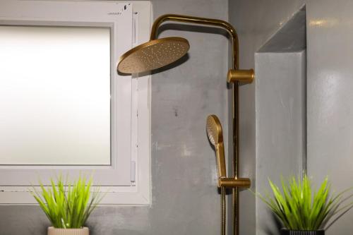 a shower head in a bathroom next to a window at ELAIA Αpartments in Alexandroupoli