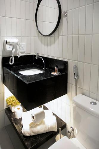 a bathroom with a black sink and a toilet at Simple Smart By Xtay - Novo, aconchegante e a 7min do Manaíra Shopping in João Pessoa