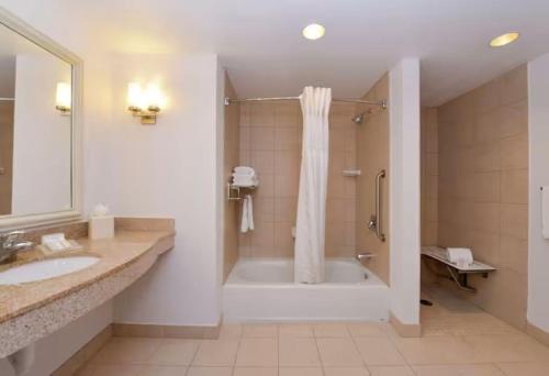 a bathroom with a tub and a shower and a sink at Hilton Garden Inn Yuma Pivot Point in Yuma