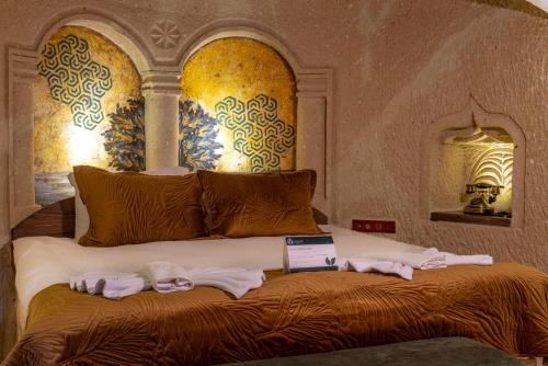 a bedroom with a bed with towels on it at Lagoon Cave Suites in Urgup