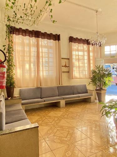 a living room with a couch and some plants at Hotel Avenida Bauru in Bauru