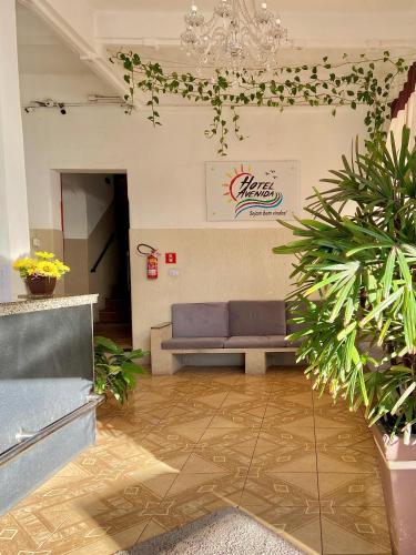 a waiting room with a blue couch in a building at Hotel Avenida Bauru in Bauru