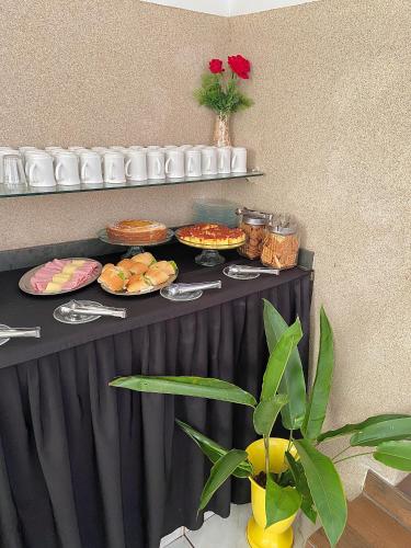 a black table with plates of food on it at Hotel Avenida Bauru in Bauru