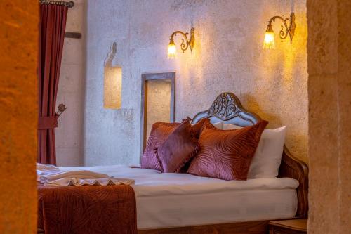 a bedroom with a bed with pillows on it at Lagoon Cave Suites in Urgup