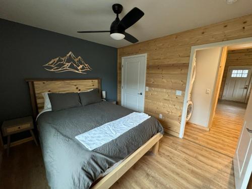 a bedroom with a bed and a ceiling fan at Kenai Adventure Cabins in Soldotna