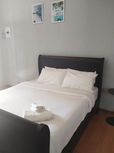 a bed with a black frame and white sheets and towels at Entire rental unit in Pretoria