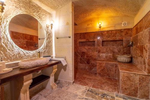 a bathroom with a shower and a sink and a mirror at Lagoon Cave Suites in Urgup