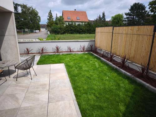 a backyard with a lawn with a table and a fence at Près colmar 6 in Wolfgantzen