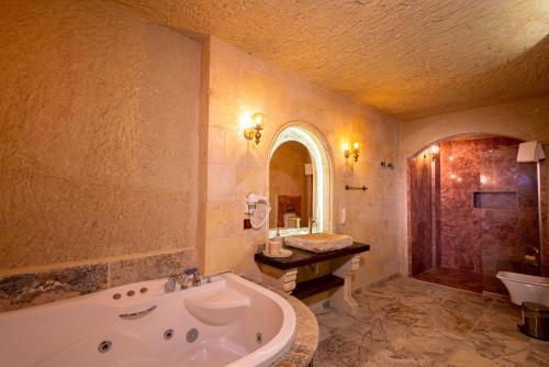 a large bathroom with a tub and a sink at Lagoon Cave Suites in Urgup