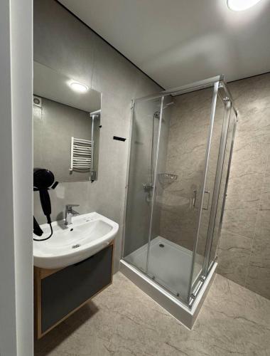a bathroom with a glass shower and a sink at Hotel Hostel Перехрестя in Chistilov