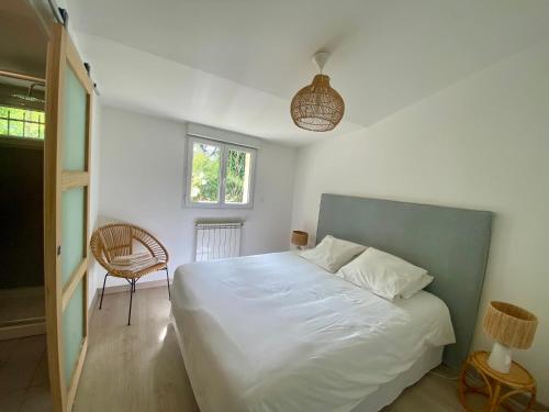 a bedroom with a bed and a chair and a window at Villa de vacances nichée dans la Garrigues, à 10 minutes d'Avignon in Villeneuve-lès-Avignon