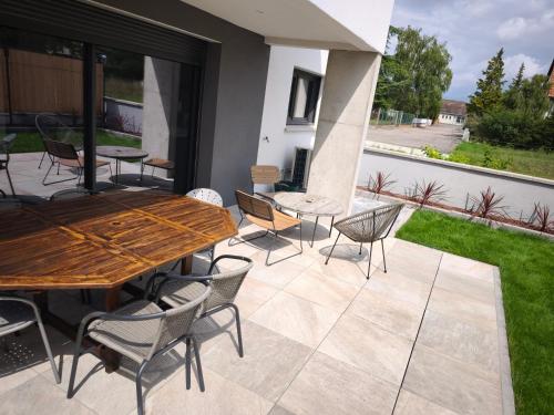 a patio with a wooden table and chairs at Près colmar 6 in Wolfgantzen