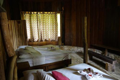 a bedroom with two twin beds and a window at Eco Hotel Sak Nok in Lacanjá