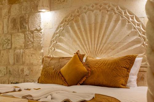 a bed with a metal headboard with two pillows at Lagoon Cave Suites in Urgup
