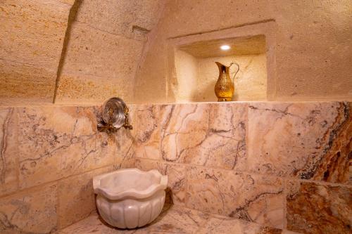 a stone bathroom with a vase on a shelf and a niche at Lagoon Cave Suites in Urgup