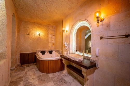 a large bathroom with a tub and a sink at Lagoon Cave Suites in Urgup