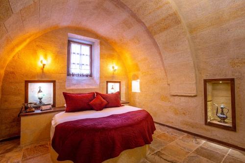a bedroom with a large bed in a stone wall at Lagoon Cave Suites in Urgup