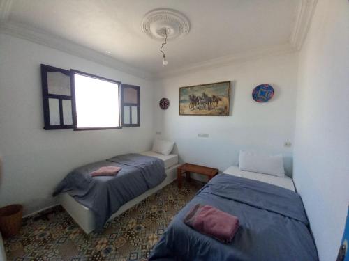 a bedroom with two beds and a window at EL Faro Surfstay in Tamri