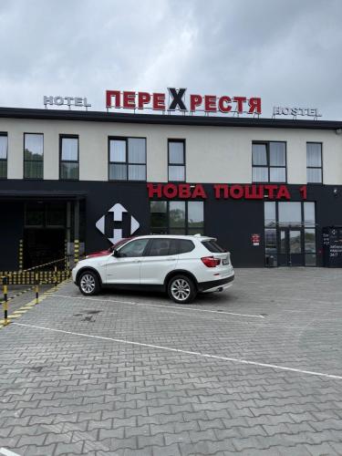 a car parked in a parking lot in front of a hotel at Hotel Hostel Перехрестя in Chistilov