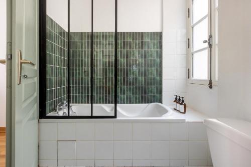 La salle de bains est pourvue d'une baignoire et d'une fenêtre. dans l'établissement La Dolce Notte - Calme & central, tout à pied, à Nantes