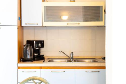 a kitchen with a sink and a microwave at Altair in Agrustos