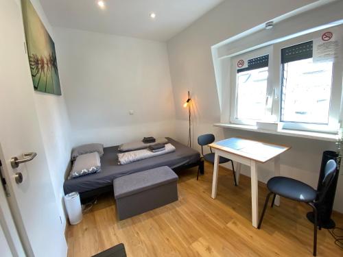 a small room with a bed and a table at Koblenz - eigenes Bad,Küche - Wifi - Parkplatz - 2 OG in Koblenz