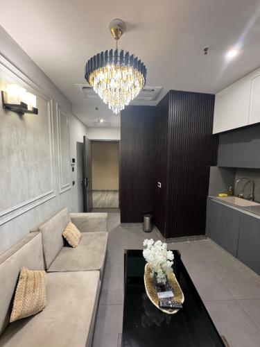 a living room with a couch and a chandelier at Supernova spira in Noida