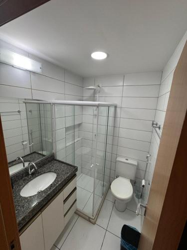 Un baño con inodoro, lavabo y ducha. en Flat Monte Castelo, en Sairé