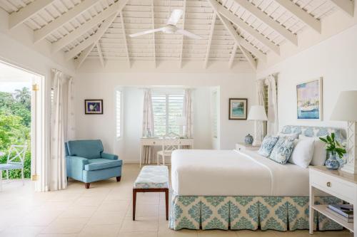a bedroom with a bed and a blue chair at Round Hill Hotel & Villas in Montego Bay