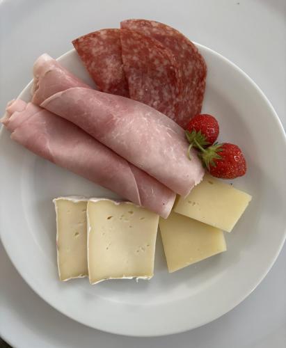 a plate of food with meat and cheese and strawberries at Agritur Stefenelli in Nago-Torbole