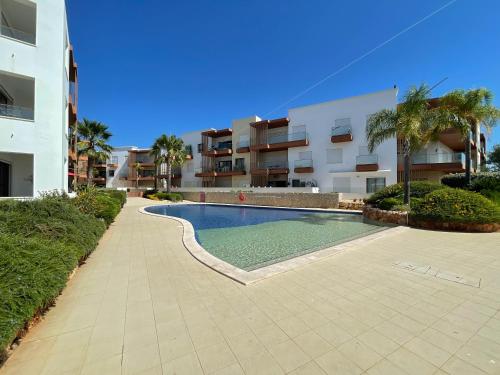 a swimming pool in front of a apartment building at Apartamento Vista Marinha in Portimão