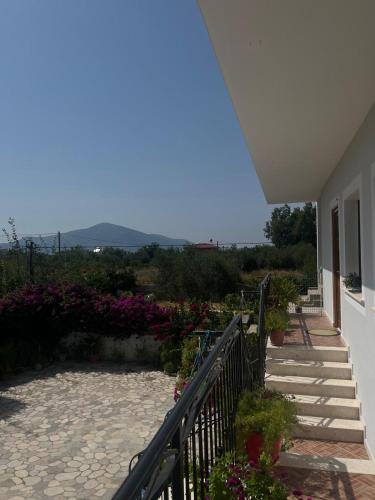 a balcony of a house with stairs and flowers at Holiday House in Polisi i Vogël