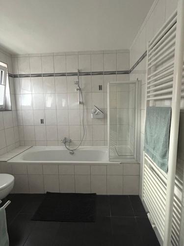 a white bathroom with a tub and a toilet at Ferienwohnung Bentheimer Wald in Bad Bentheim