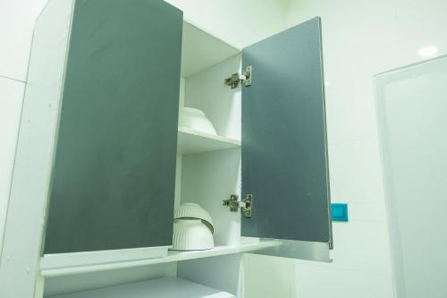 a cupboard with a mirror in a bathroom at Queens Court Apartments in Effurun
