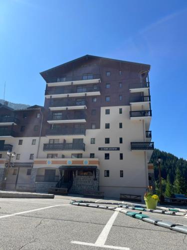 a large building with a parking lot in front of it at Le grand argentier - valfrejus in Modane