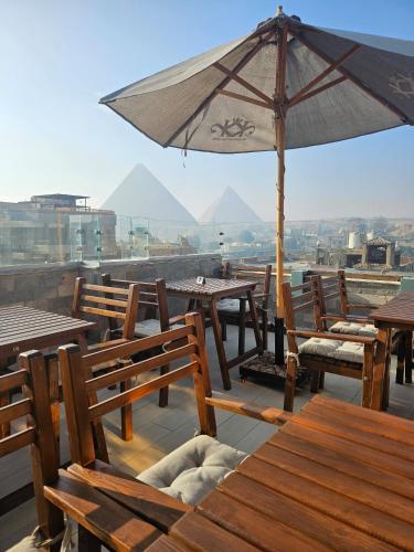 a table and chairs with an umbrella on a roof at The Home Boutique Hotel Pyramids Inn in Cairo