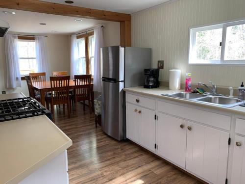 une cuisine avec un réfrigérateur en acier inoxydable et une table dans l'établissement Green River Cottage, à Guilford