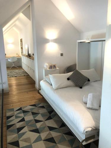 une chambre avec un grand lit blanc avec un miroir dans l'établissement Duplex Hyper Centre, Vue MontBlanc Chamonix, à Chamonix-Mont-Blanc